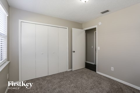 a bedroom with two closets and a door to a hallway