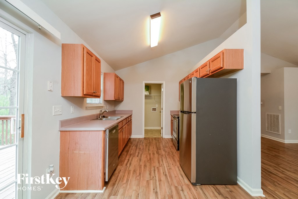 A kitchen with wooden floors and cabinets.