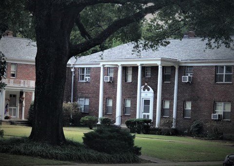 a large brick house with a tree in front of it