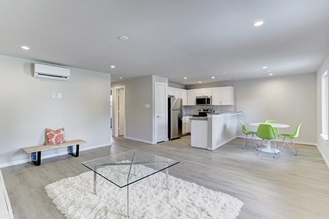 A modern kitchen with a glass table and white walls.