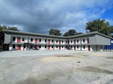 A grey building with red and white doors.