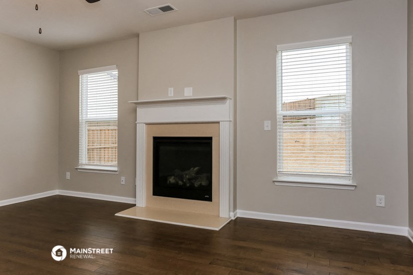 a living room with a fireplace and a wooden floor