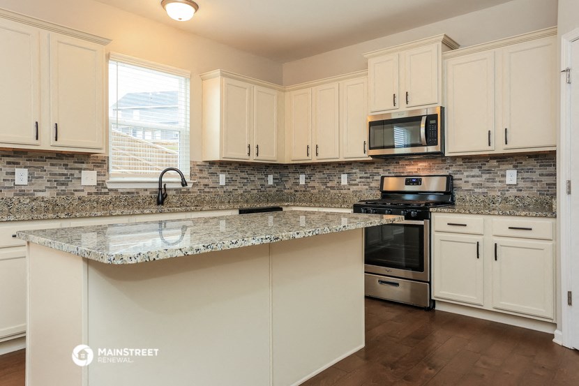 a kitchen with white cabinets and a granite counter top