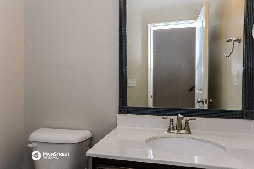 a bathroom with a toilet and a sink and a mirror