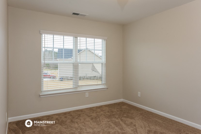 a room with a large window and a carpeted floor