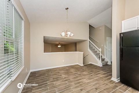 the kitchen and living room of a house with a large window
