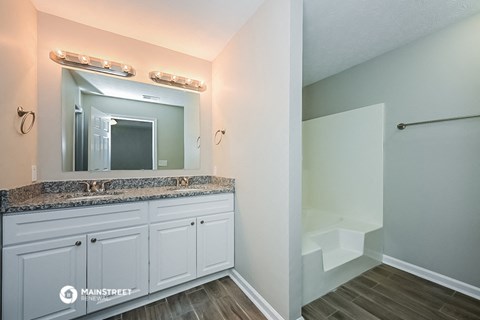 a bathroom with white cabinets and a sink and a mirror