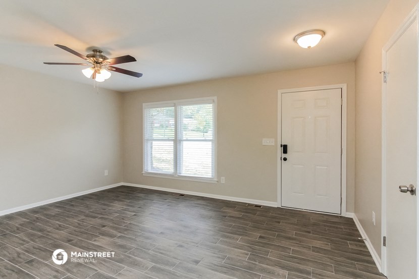 the bedroom of the bridgewater house has a large window and a ceiling fan