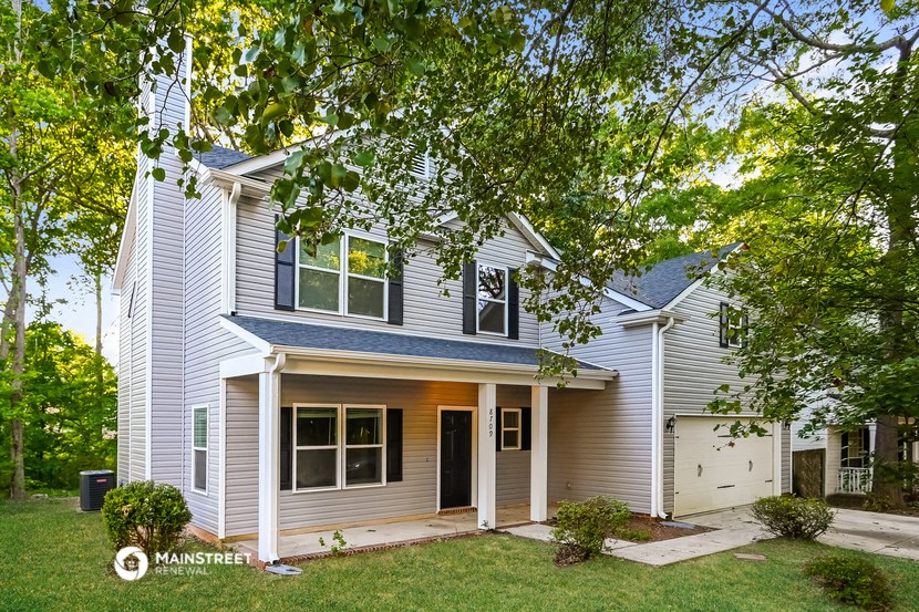 a white house with a lawn and trees