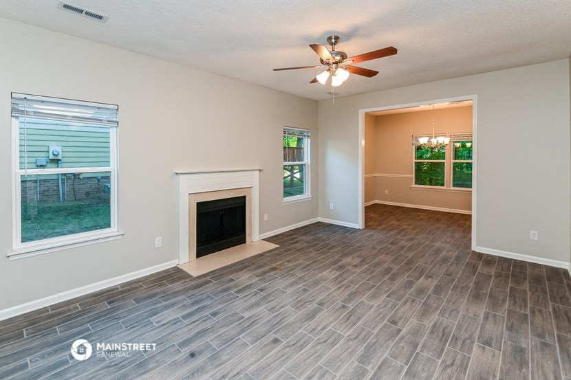 a living room with a fireplace and a ceiling fan