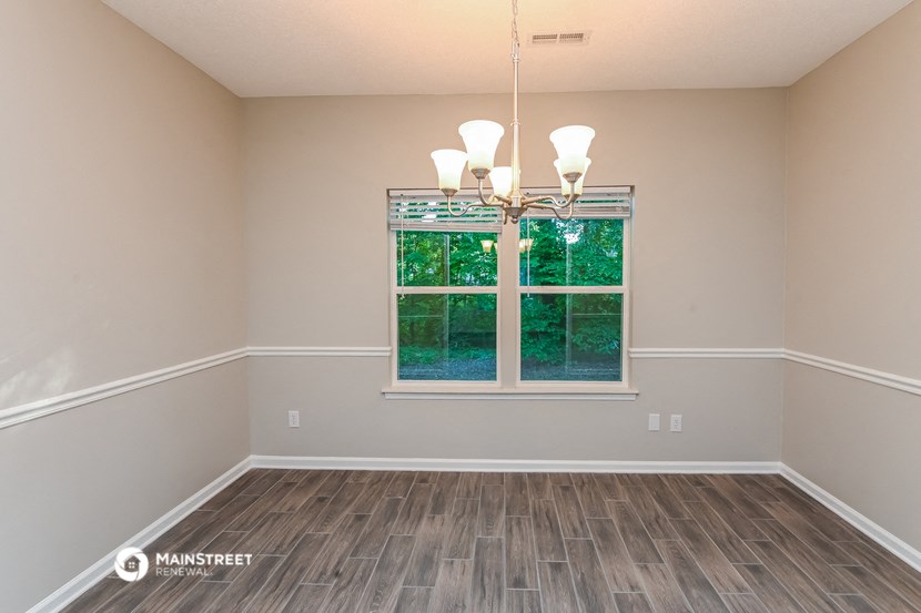 an empty living room with wood floors and a window