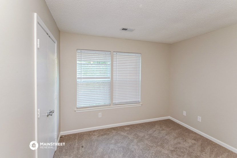 an empty room with a window and a door