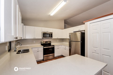 a kitchen with white cabinets and stainless steel appliances