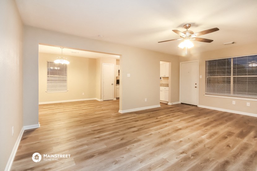 the living room of an empty house with a ceiling fan