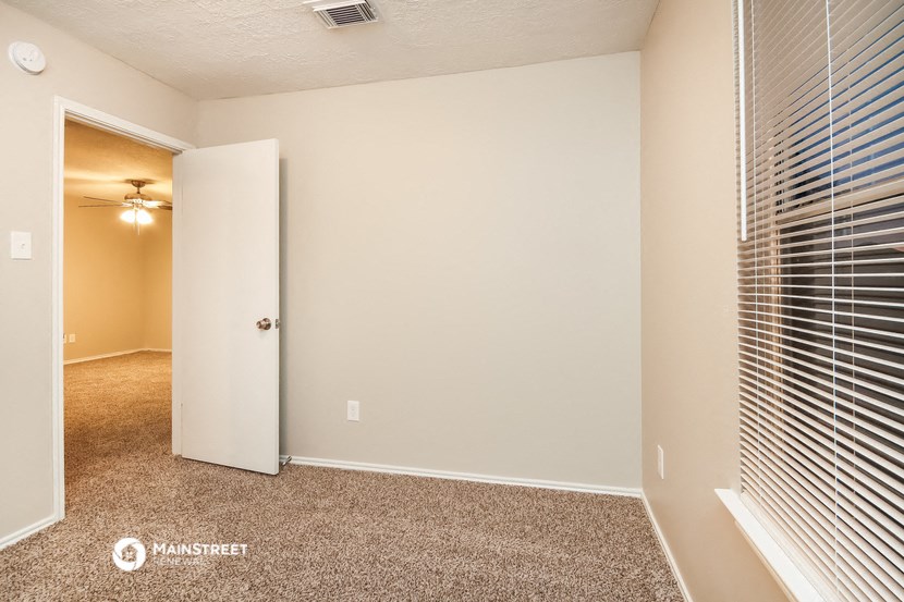 a bedroom with a door to a closet and a window