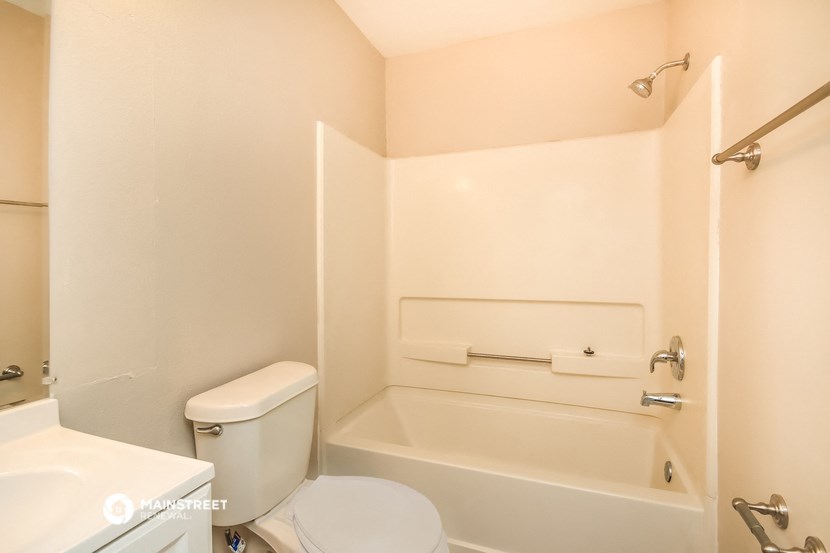 a bathroom with a toilet and a tub and a sink