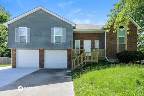 a gray house with a white garage door and a porch