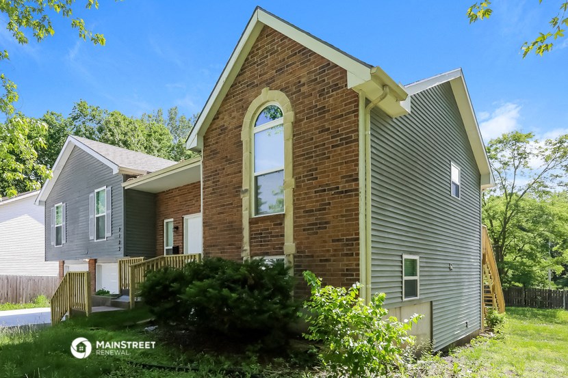 the front of a house with a large window on the side of it