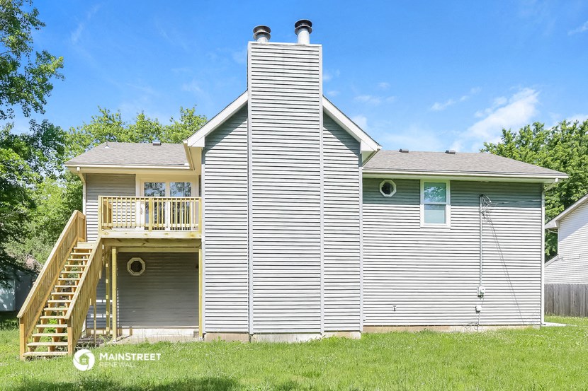 a view of the back of a house with a garage and a deck