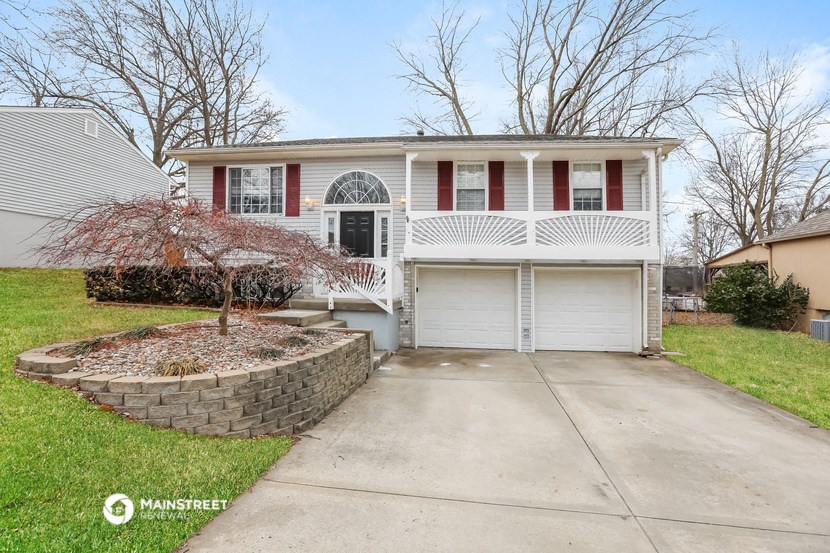 a white house with red shutters and a white garage door