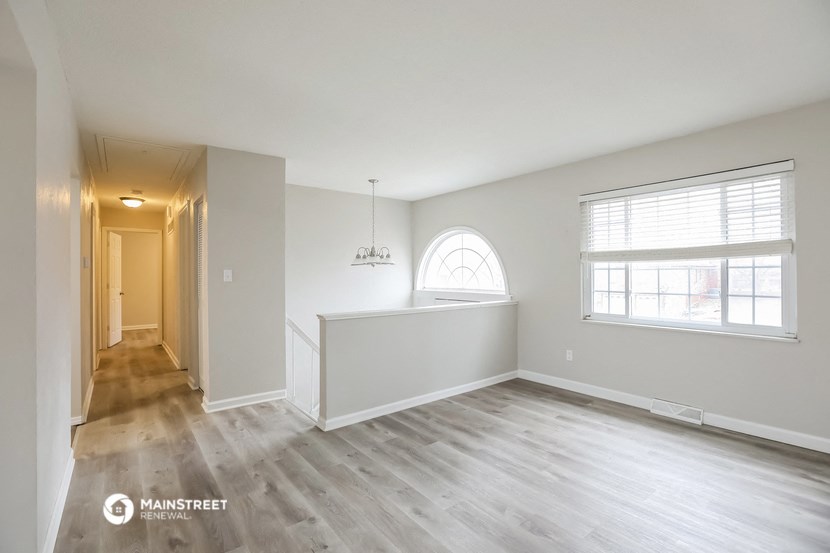 an empty living room with white walls and wood floors