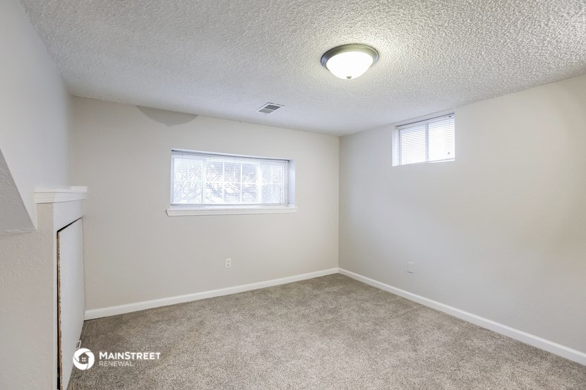 an empty room with carpet and a window