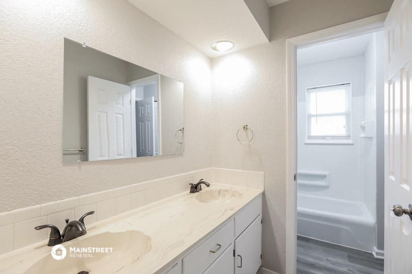 a bathroom with a sink and a mirror and a shower