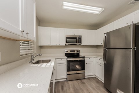 a kitchen with white cabinets and stainless steel appliances