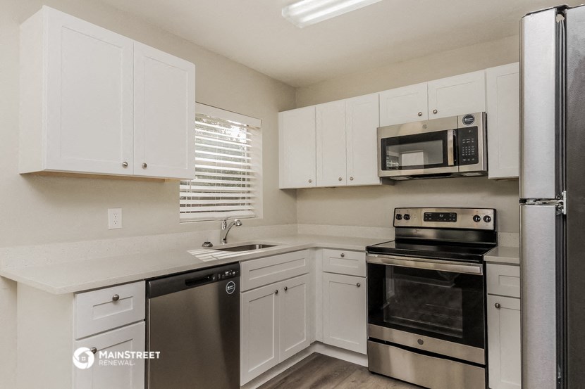 a kitchen with white cabinets and stainless steel appliances
