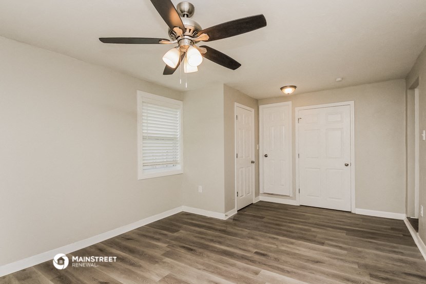the spacious living room with ceiling fan and closet