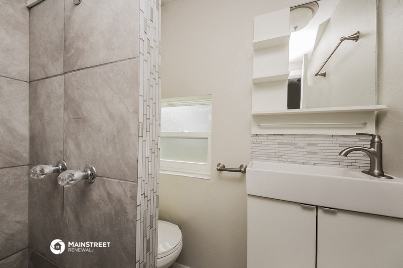 a bathroom with a shower and a sink and a toilet