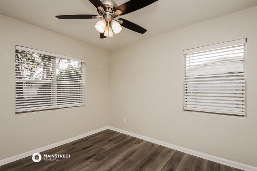 the interior of a bedroom with a ceiling fan and a window