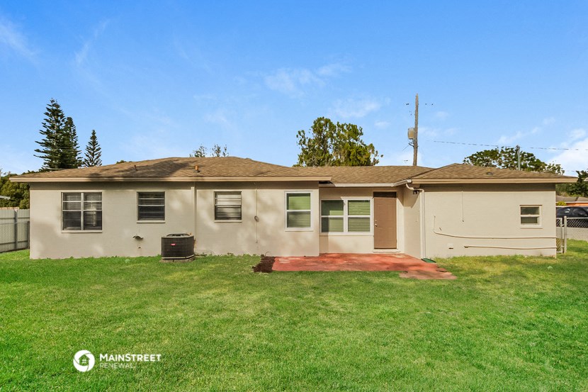 a beige house with a yard and a driveway