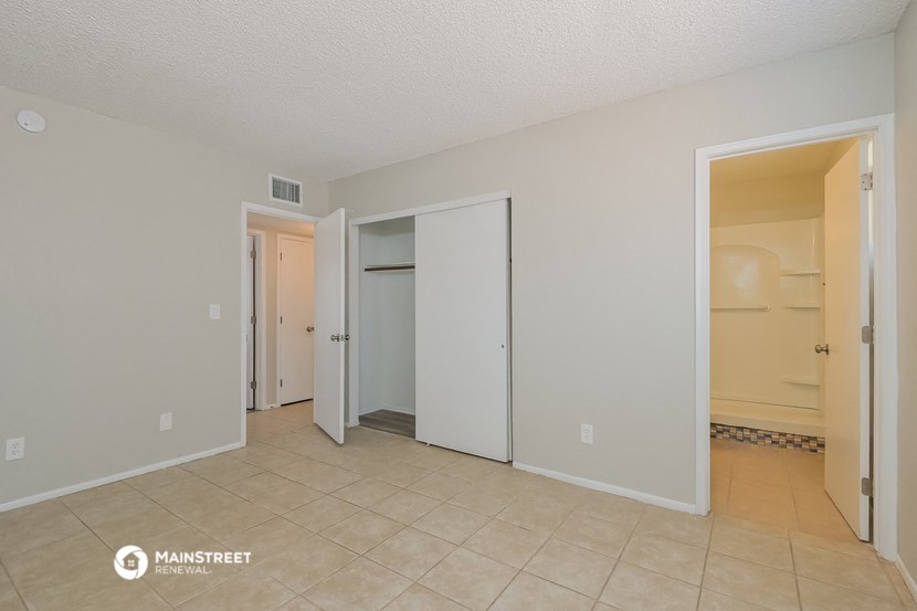 the spacious living room with two closets and a tiled floor
