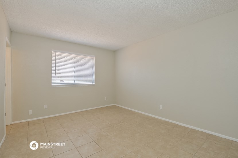 the spacious living room with tiled floors and a window