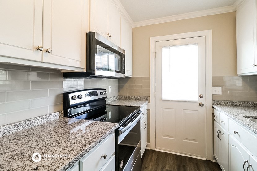a kitchen with granite counter tops and black appliances