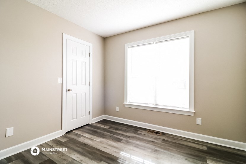 the living room of a new home with a door and a window