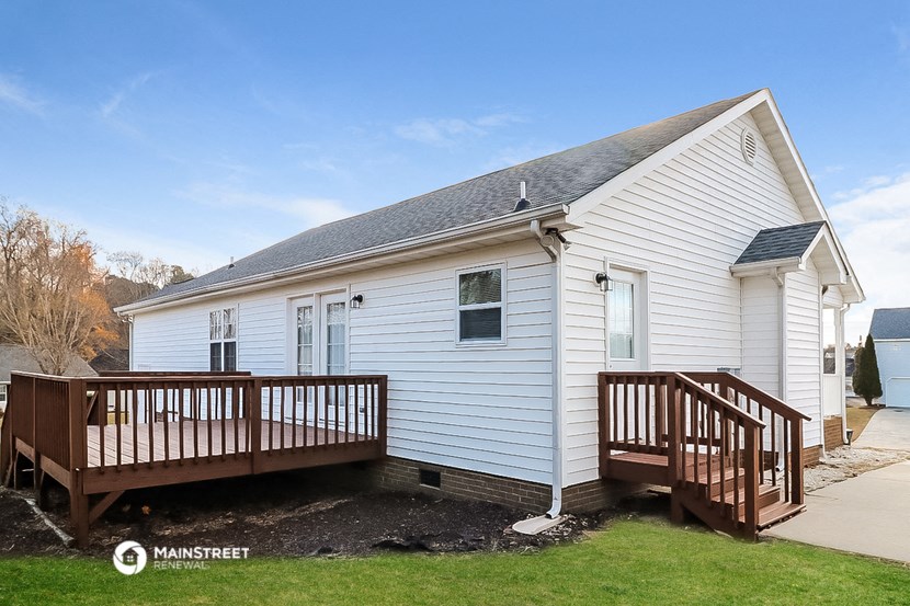 a white house with a porch and a wooden deck