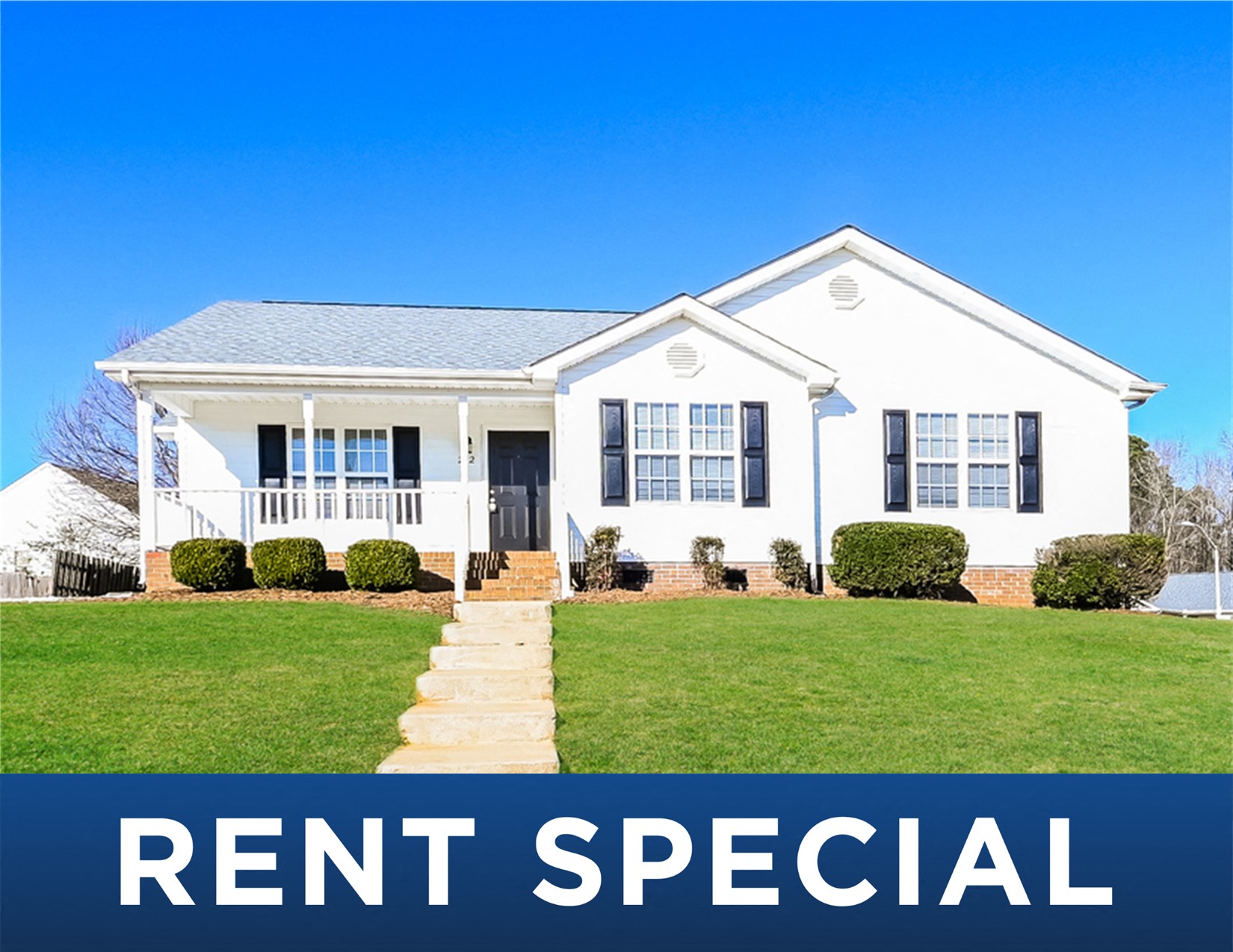 a white house with a lawn and the rent special sign