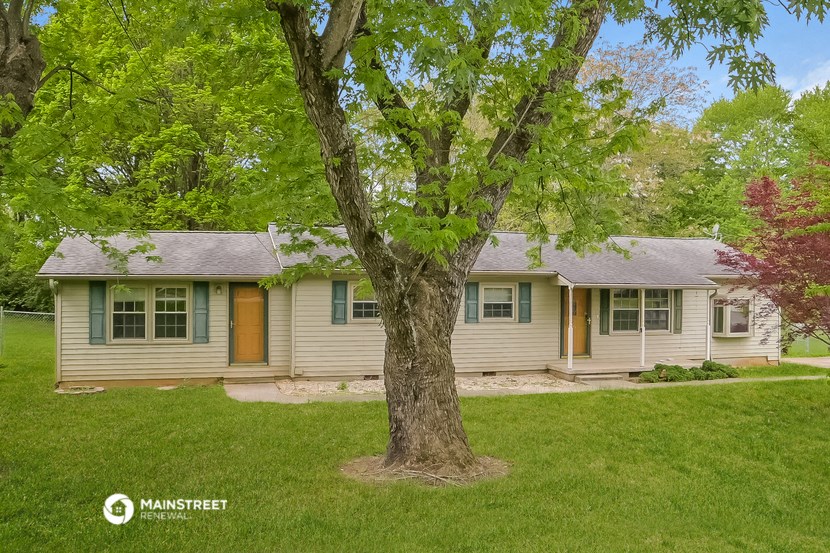 a white house with a large tree in front of it