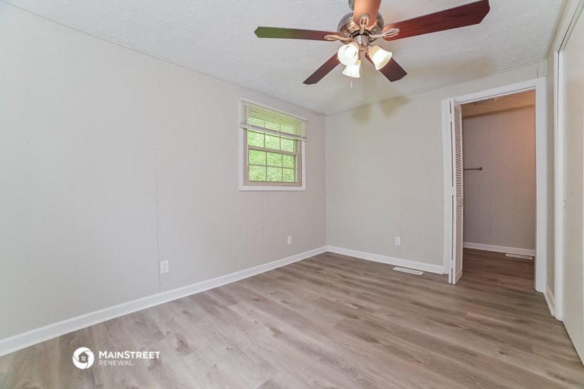 the living room of an empty house with a ceiling fan