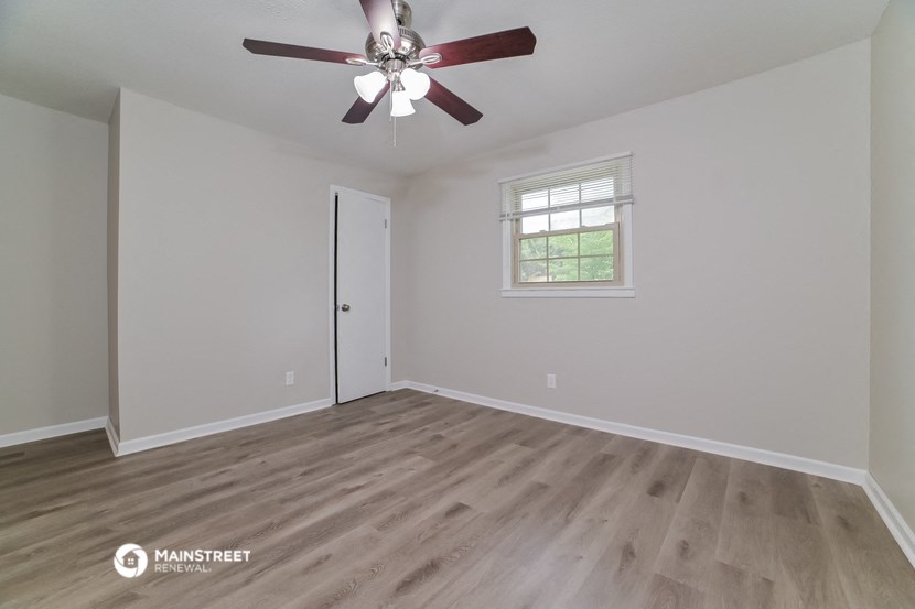 the living room of an empty house with a ceiling fan