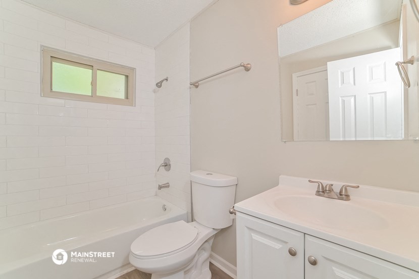 a bathroom with a toilet and a sink and a tub