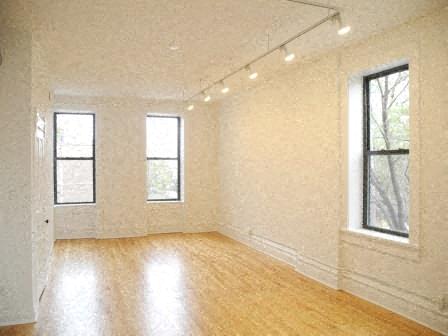 an empty living room with white walls and a wooden floor