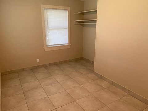 an empty room with a closet and a window