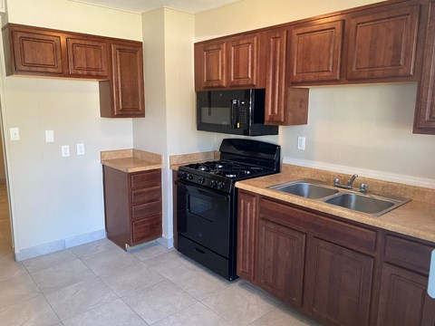 a kitchen with black appliances and wooden cabinets