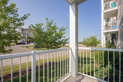 A white balcony with a white railing and a white pillar.