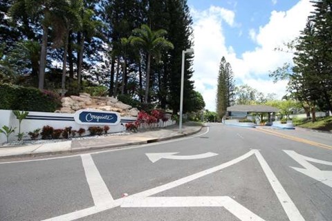 A road with a sign that says "Originalz" in front of a forest.