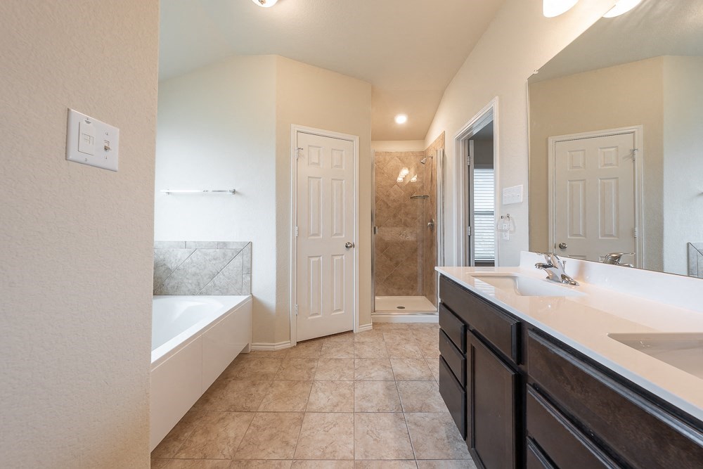 a bathroom with a tub and a sink and a mirror