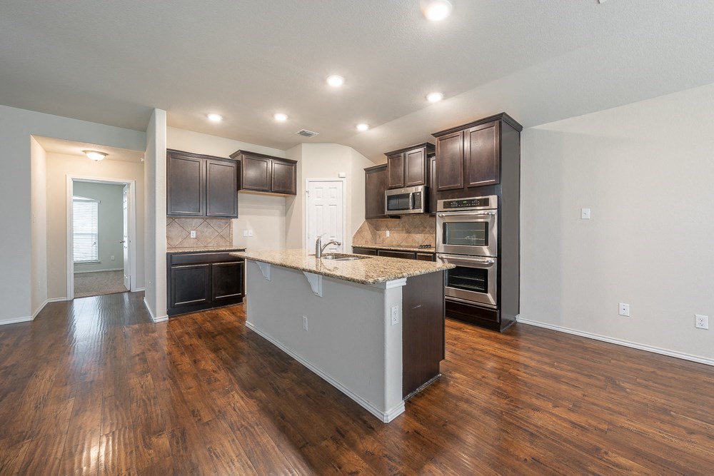 a kitchen with stainless steel appliances and a marble counter top